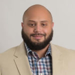 bearded man in suit smiling at camera - Mike Acerra